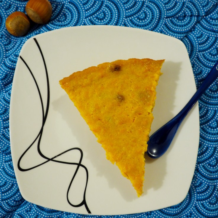 Part de tarte au potiron sur assiette carrée et nappe bleue