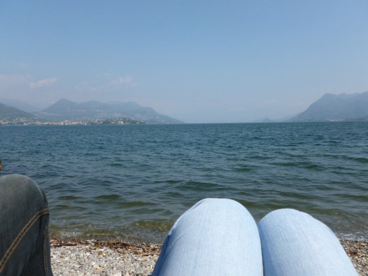 Vue sur le lac Majeur depuis sa rive, genoux au premiers plan