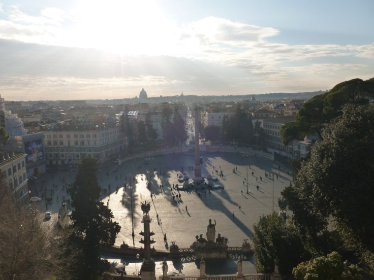 Vue éblouissante et plongeante sur la piazza del Popolo, Rome. Au loin la silhouette de la basilique Saint-Pierre émerge de l'horizon.