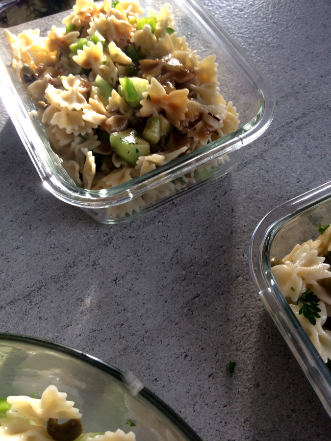 Salade de pâtes dans contenant en verre sous un rayon de soleil