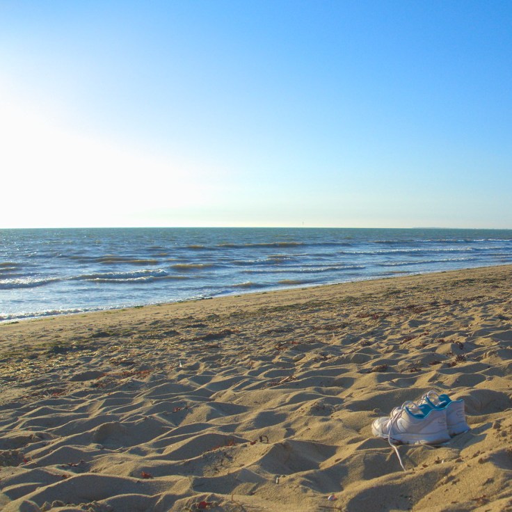 Baskets à la plage regardant vers l'océan
