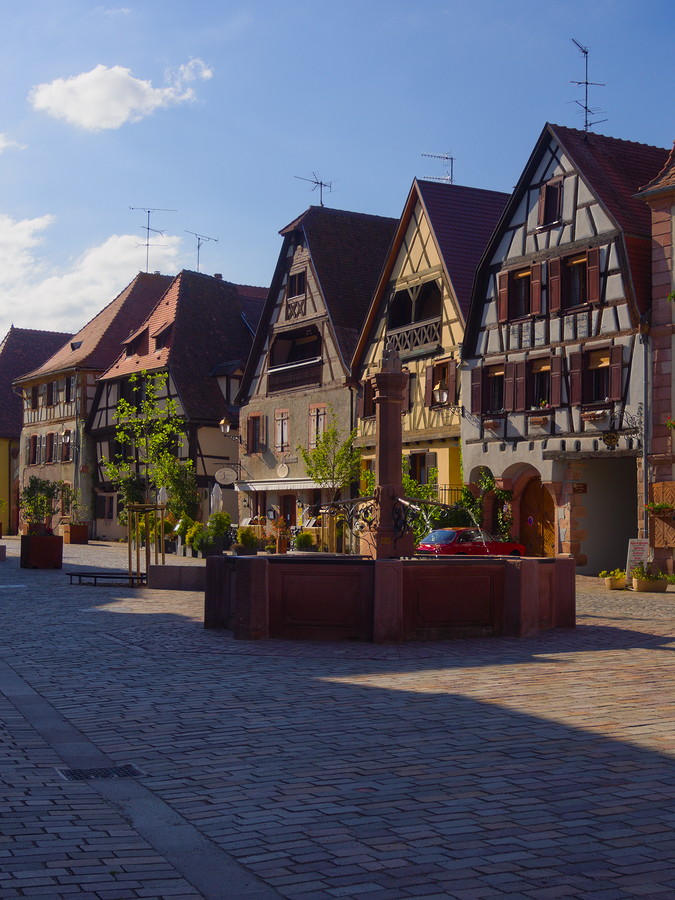 maisons à colombages donnant sur place pavée avec fontaine centrale