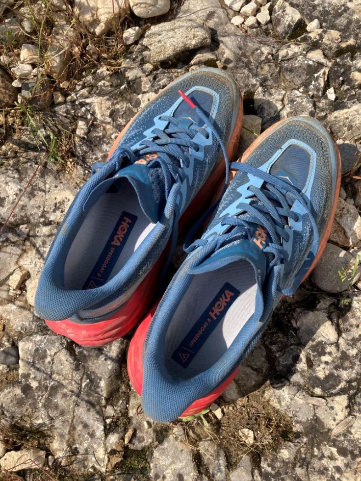 Paire de chaussures de trail sur sol rocheux.